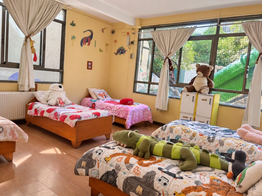 Dormitorio de la residencia, con camas y peluches