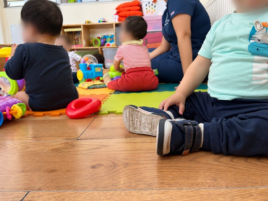 Niños jugando en el suelo junto a las educadoras de la residencia